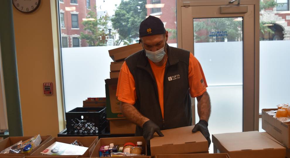 Volunteer Mark Mackin packs boxes of food at an ABCD food bank in Roxbury.
Craig LeMoult / WGBH News